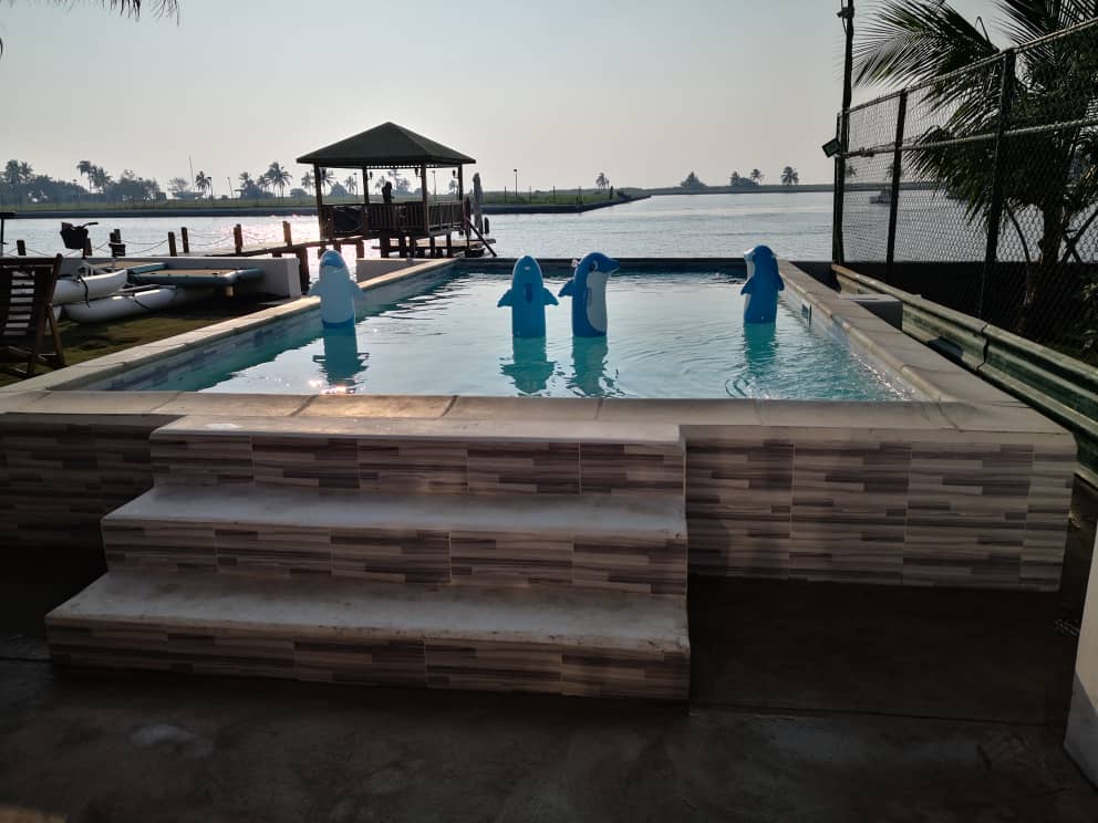 casa-festiva-en-santa-fe Piscina para fiestas con escultura de delfines frente al mar